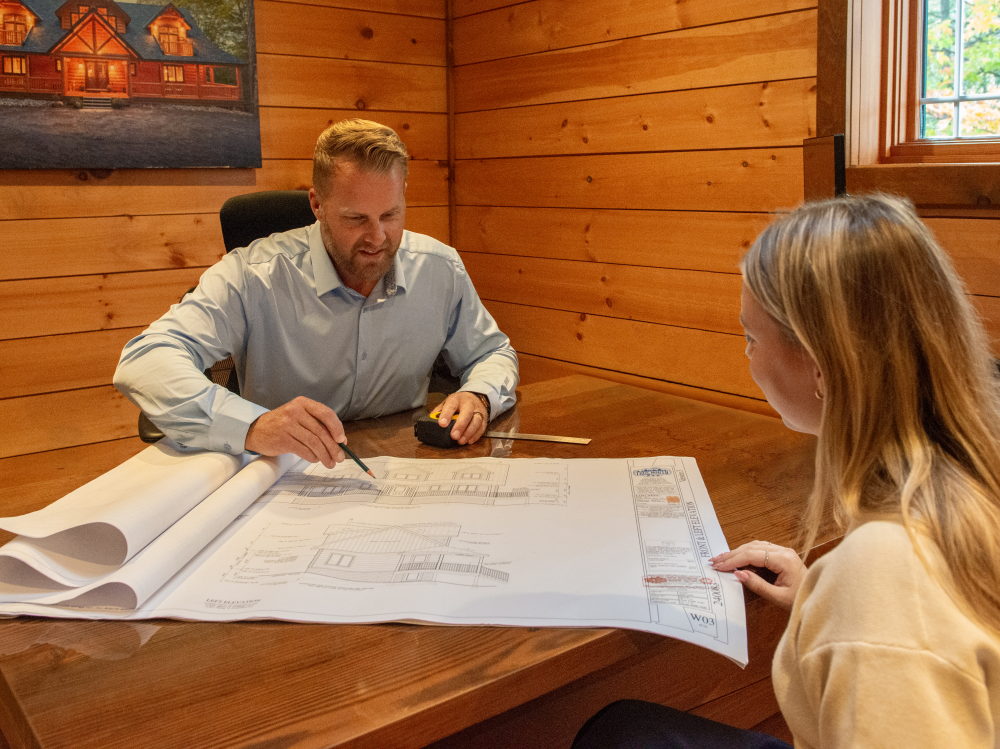 A Sales & Design Consultant meets with a prospective client to discuss her plans for her dream log home.